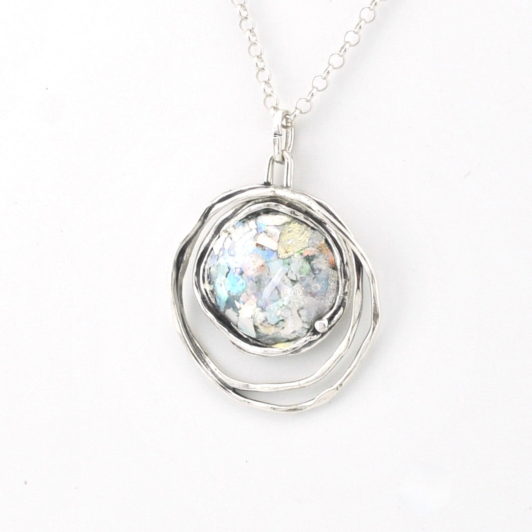 Silver pendant with a Roman glass on a white background