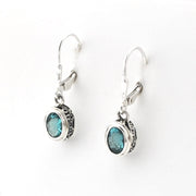 Silver earrings with blue gemstones on a white background