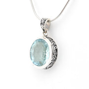 Silver pendant with a blue gemstone on a white background