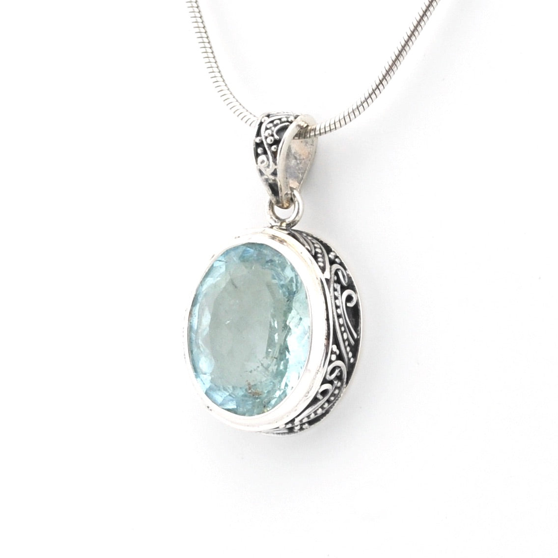 Silver pendant with a blue gemstone on a white background