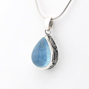 Teardrop-shaped blue pendant with silver frame on a white background