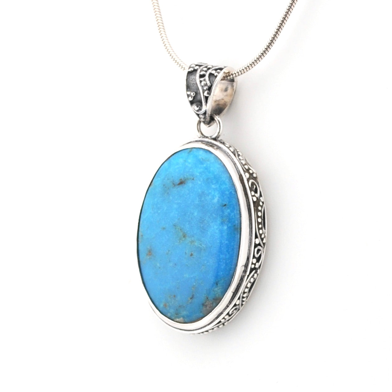Turquoise pendant with silver setting on a white background