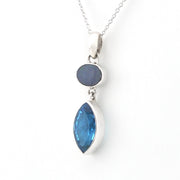 A silver pendant necklace featuring a marquise-cut blue gemstone and a smaller oval dark blue gemstone, shown on a plain white background.