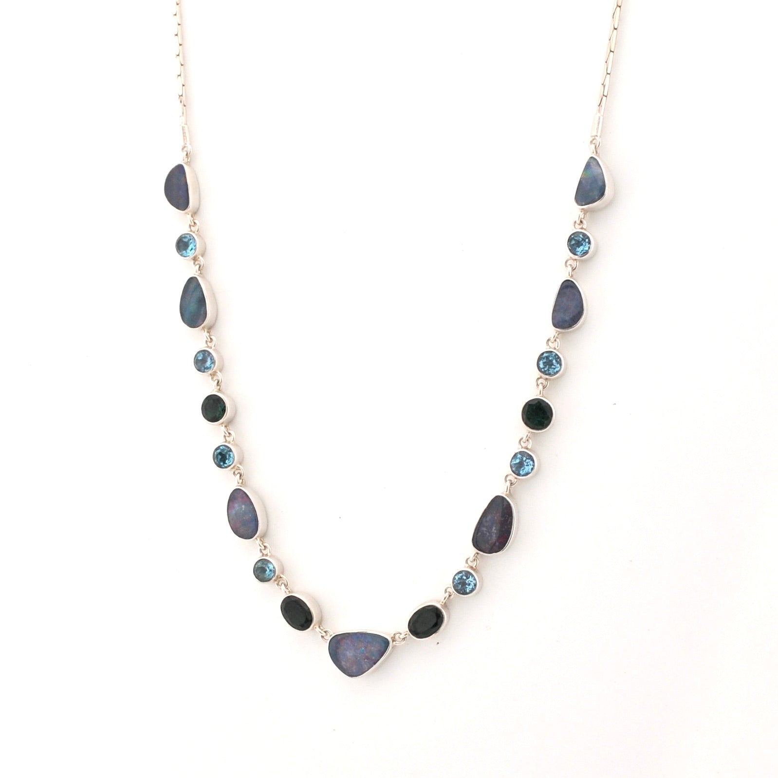 Necklace with opals, blue topaz and green quartz stones on a white background