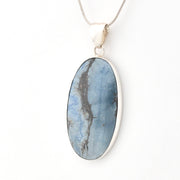 Oval-shaped blue stone pendant on a white background