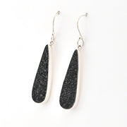 Black teardrop earrings with silver hooks on a white background