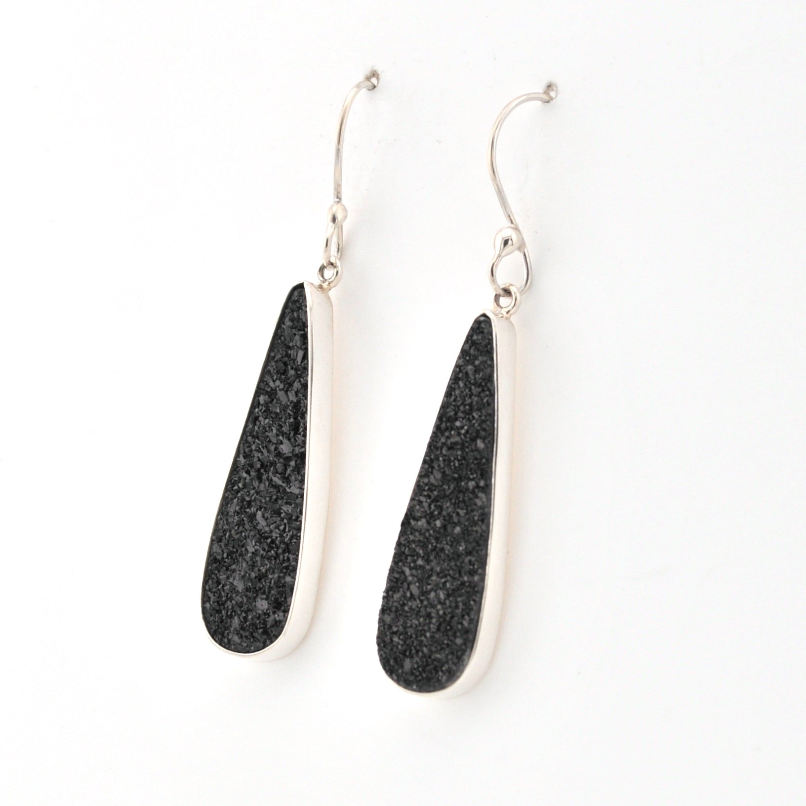 Black teardrop earrings with silver hooks on a white background