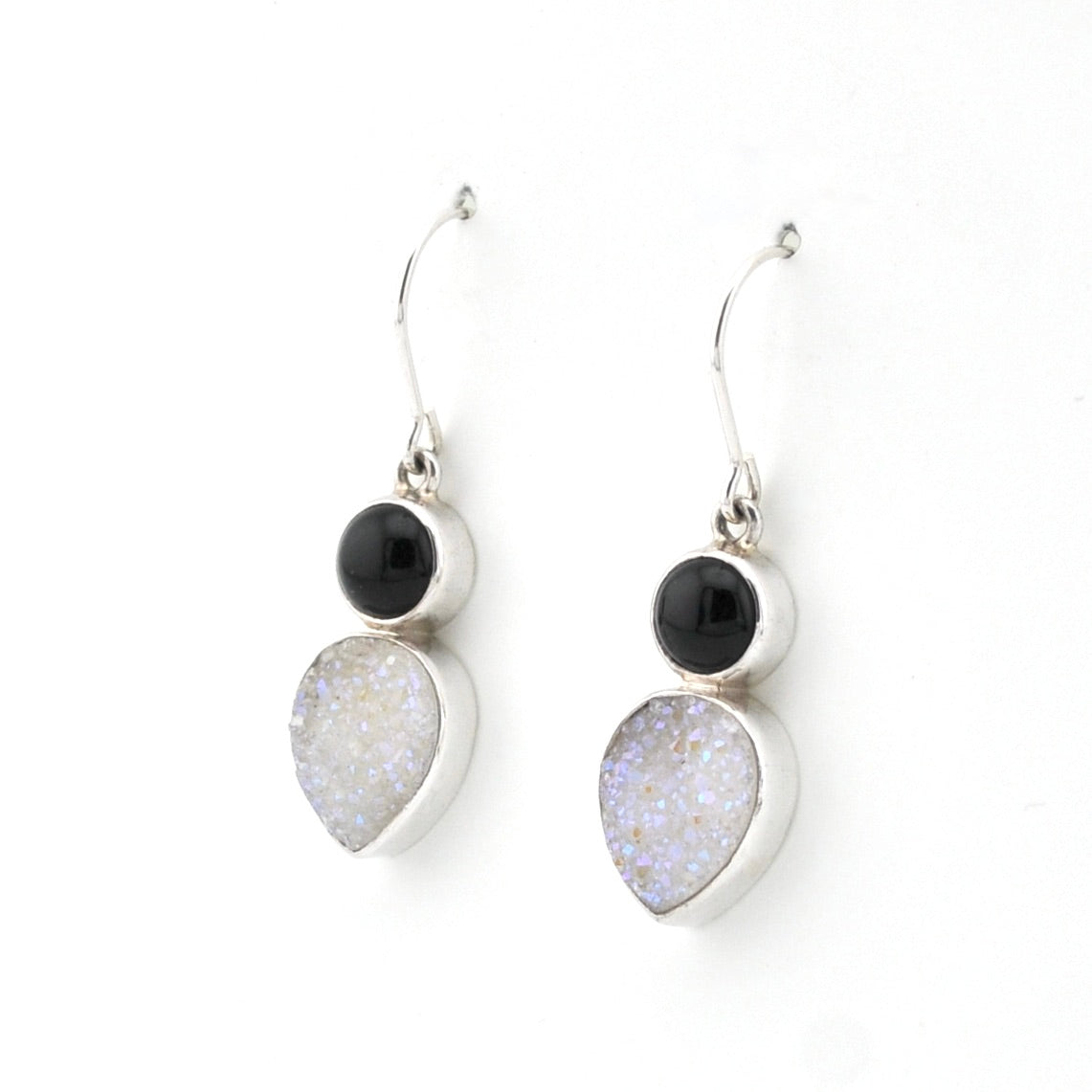 Pair of earrings with black and white stones on a white background