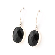 Black oval earrings on silver hooks against a white background
