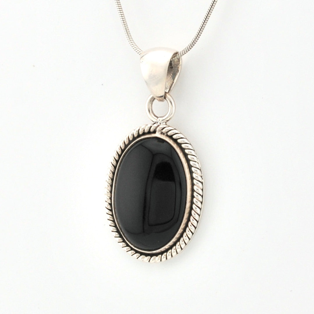 Black stone pendant on a silver chain against a white background