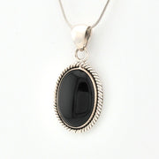 Black stone pendant on a silver chain against a white background