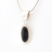 Black oval pendant on a silver chain against a white background