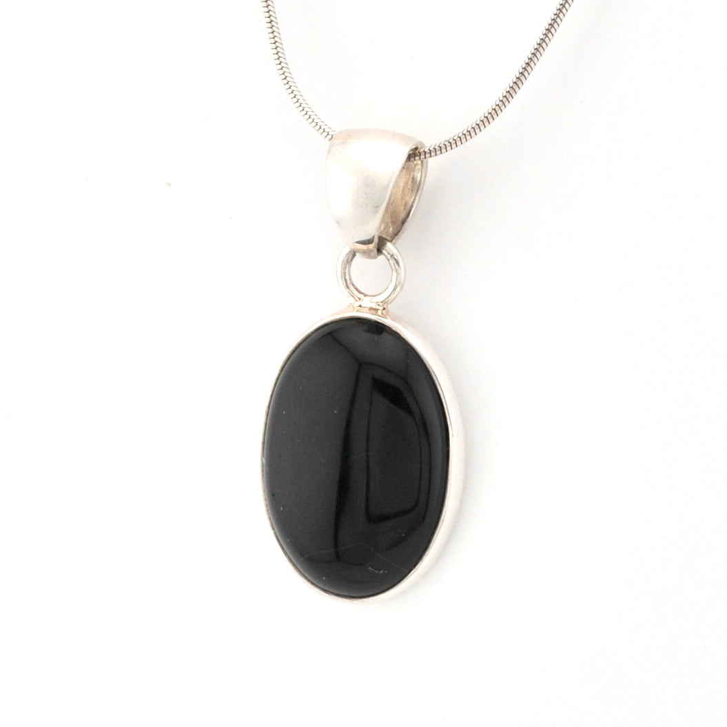 Black pendant on a silver chain against a white background