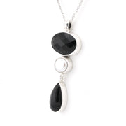 Necklace with black gemstones and silver pendants on a white background