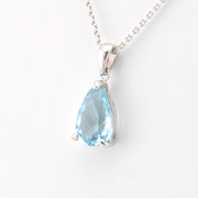 Teardrop-shaped blue gemstone pendant on a white background