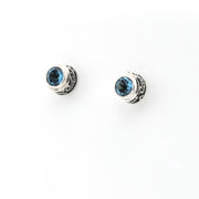 Pair of silver earrings with blue gemstones on a white background
