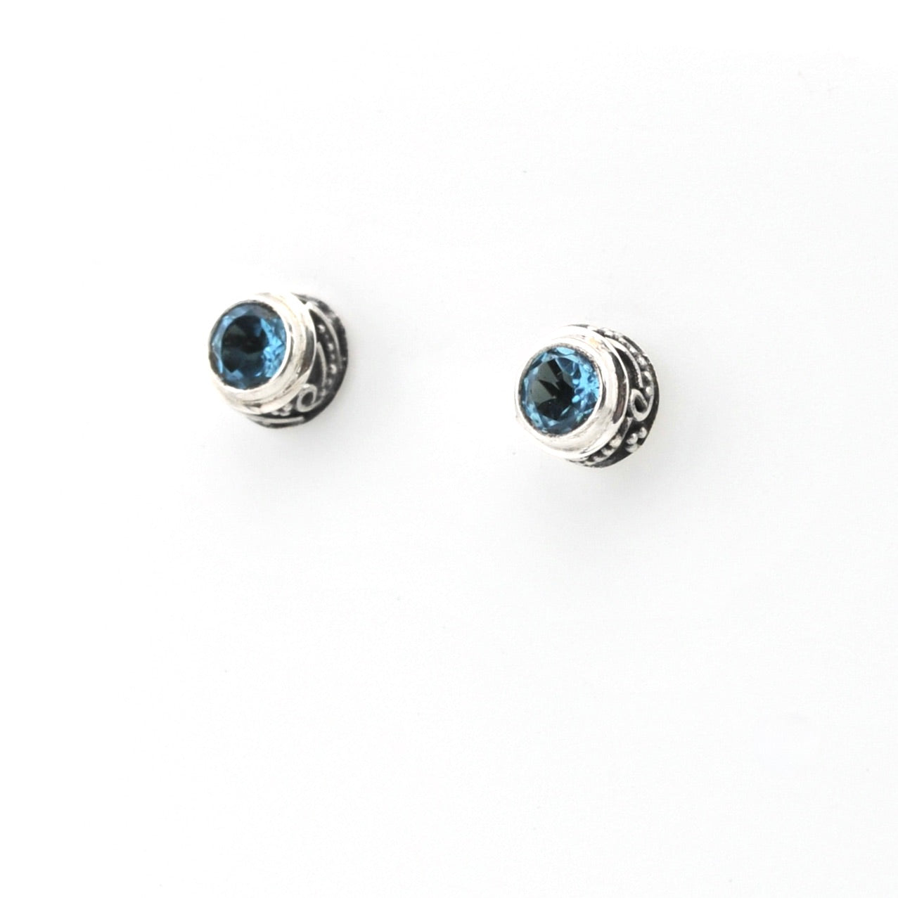 Pair of silver earrings with blue gemstones on a white background