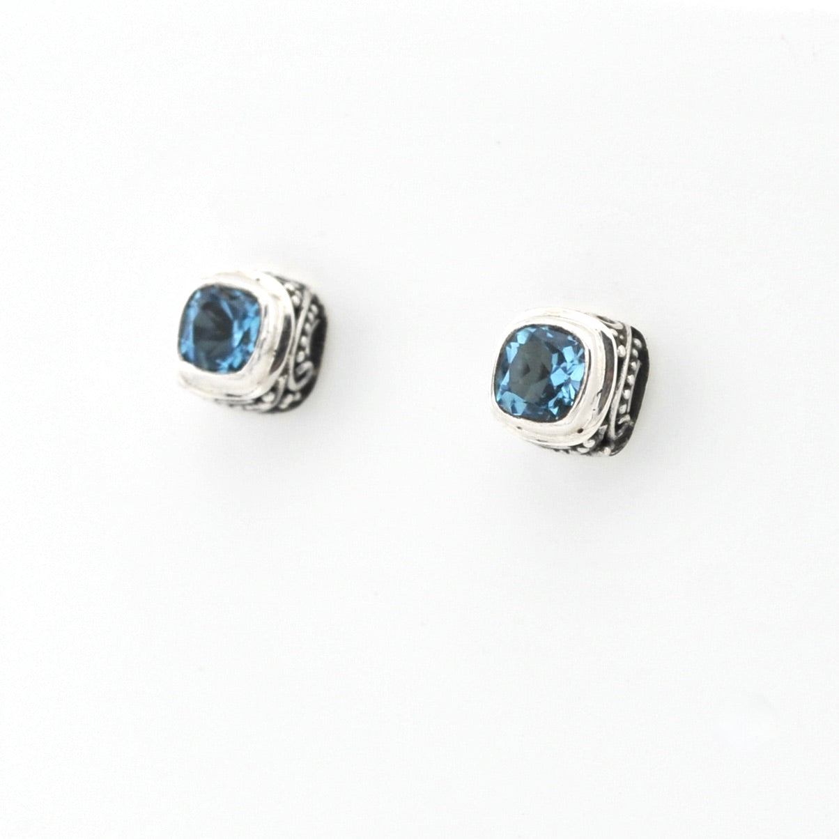 Pair of silver stud earrings with blue gemstones on a white background