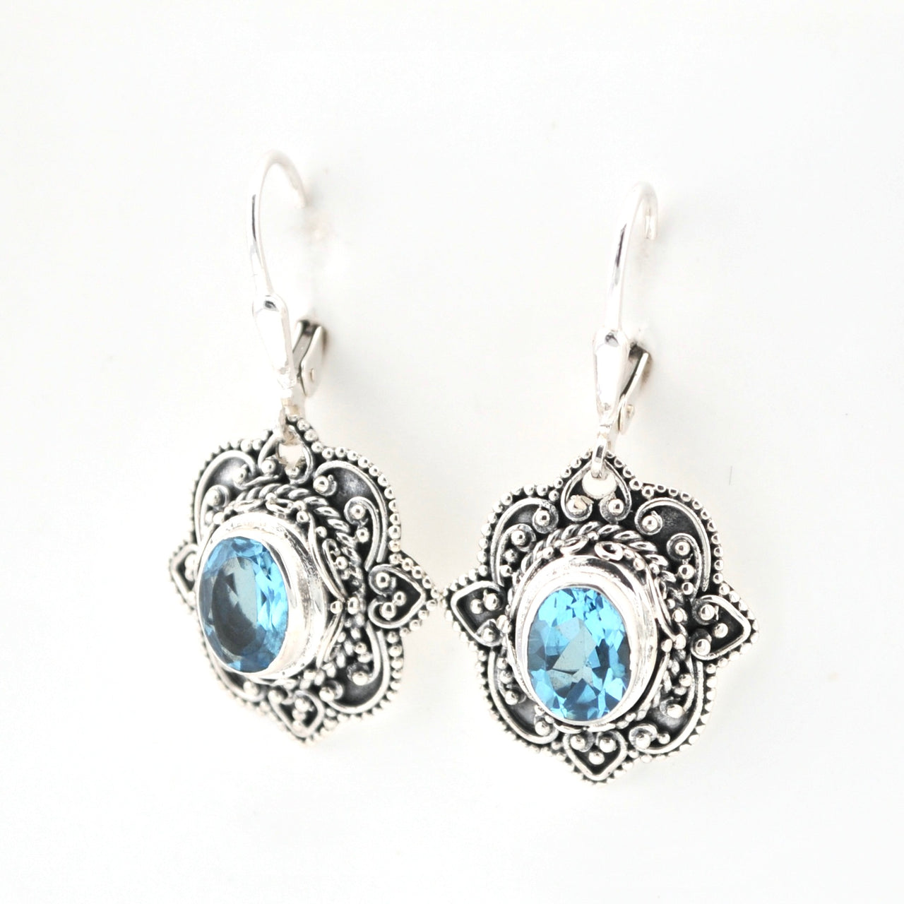 Silver earrings with blue gemstones on a white background