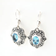 Silver earrings with blue gemstones on a white background