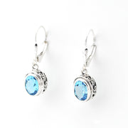 Silver earrings with blue gemstones on a white background