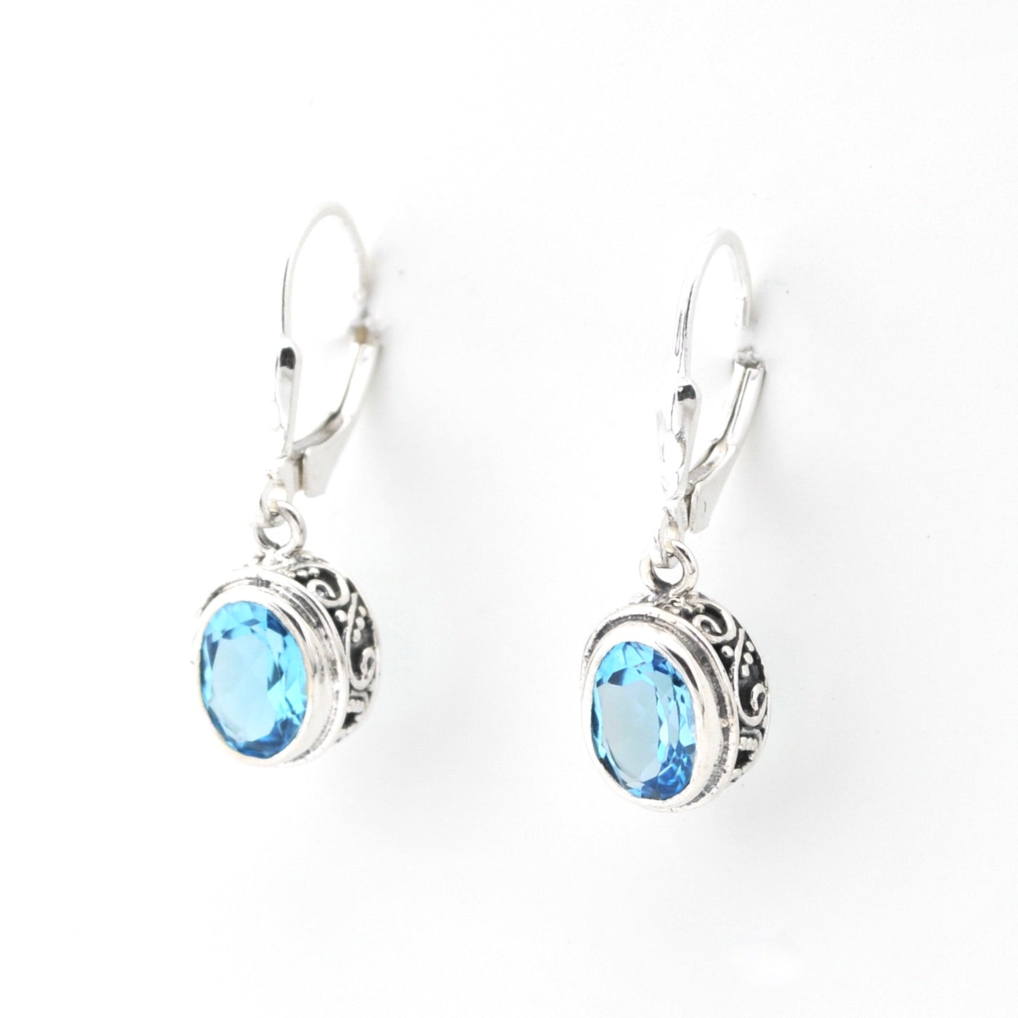 Silver earrings with blue gemstones on a white background
