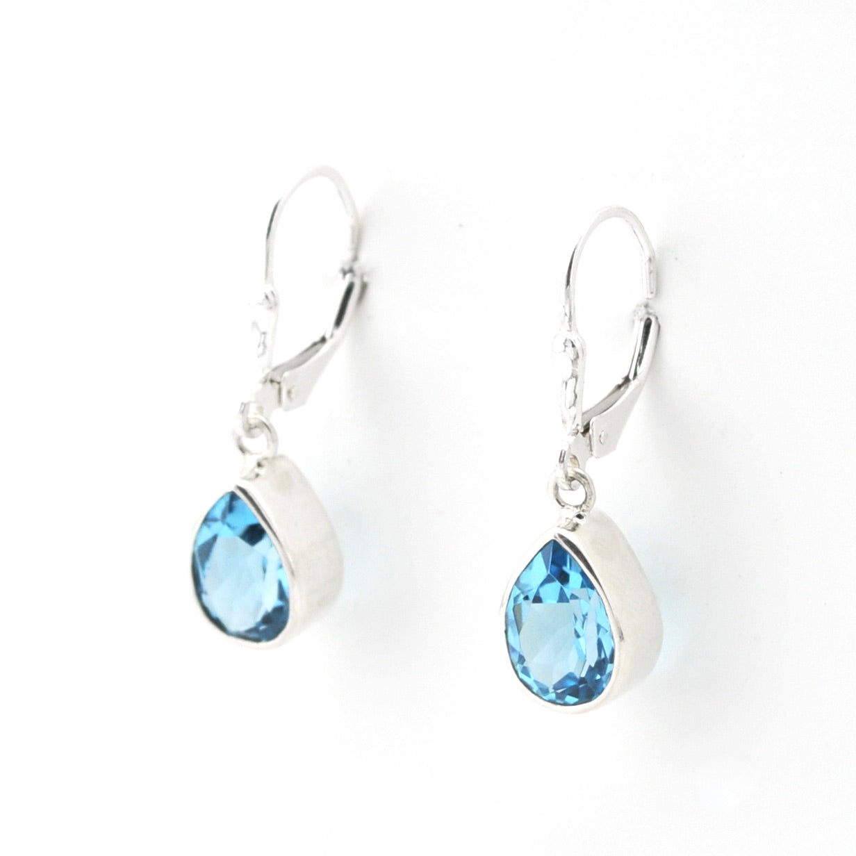 Pair of silver earrings with blue gemstones on a white background