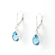 Pair of silver earrings with blue gemstones on a white background