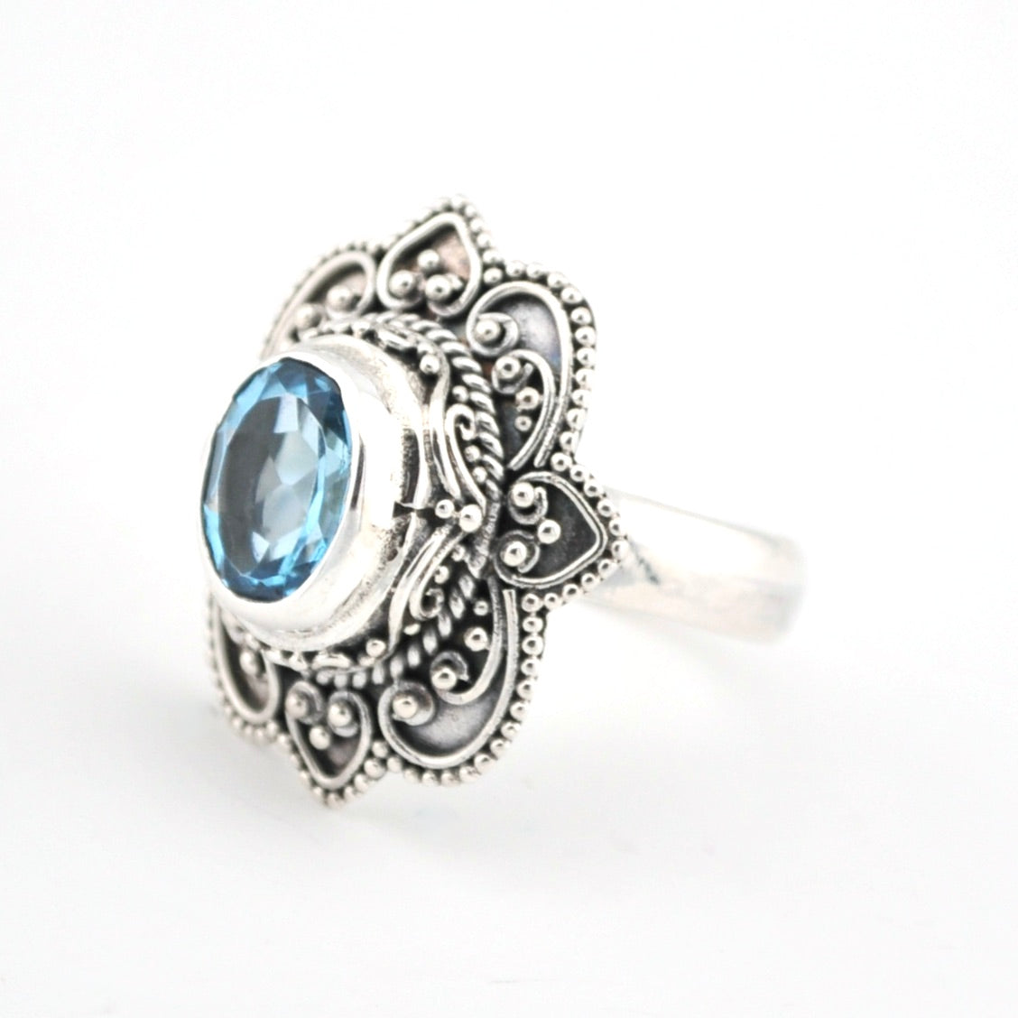 Silver ring with blue gemstone on a white background
