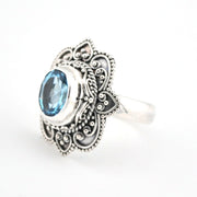 Silver ring with blue gemstone on a white background