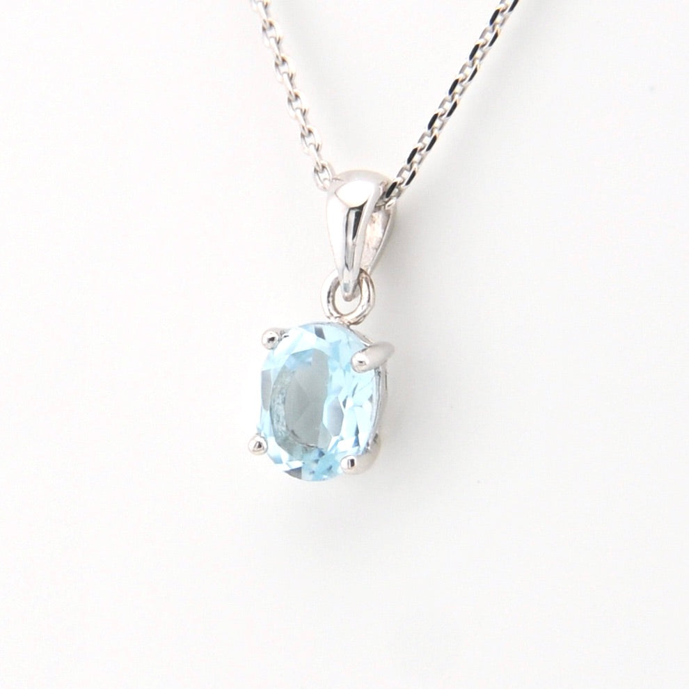 Silver necklace with a blue gemstone pendant on a white background