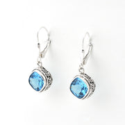 Silver earrings with blue gemstones on a white background