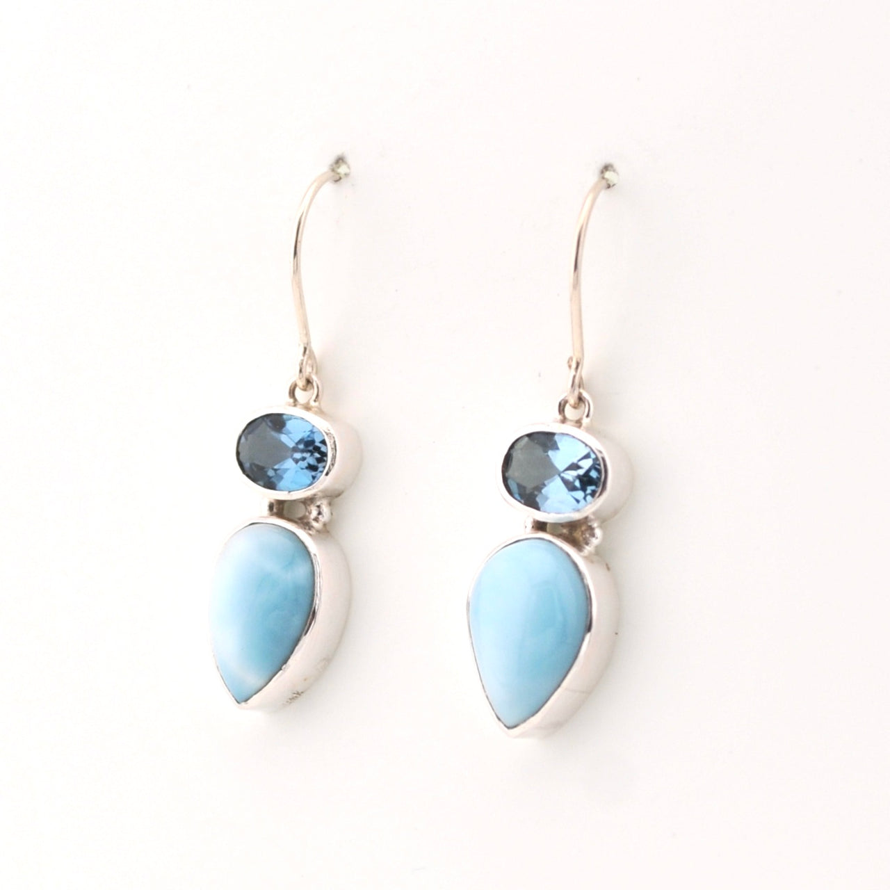 Pair of earrings with blue teardrop-shaped stones on a white background