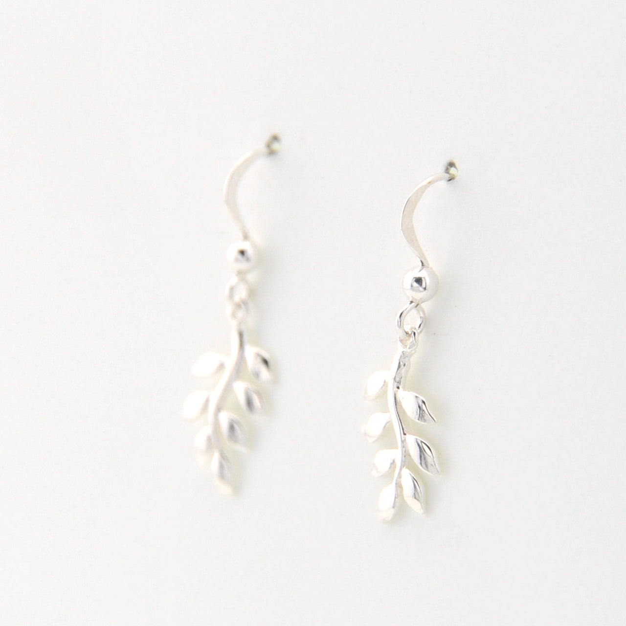Silver leaf-shaped earrings on a white background