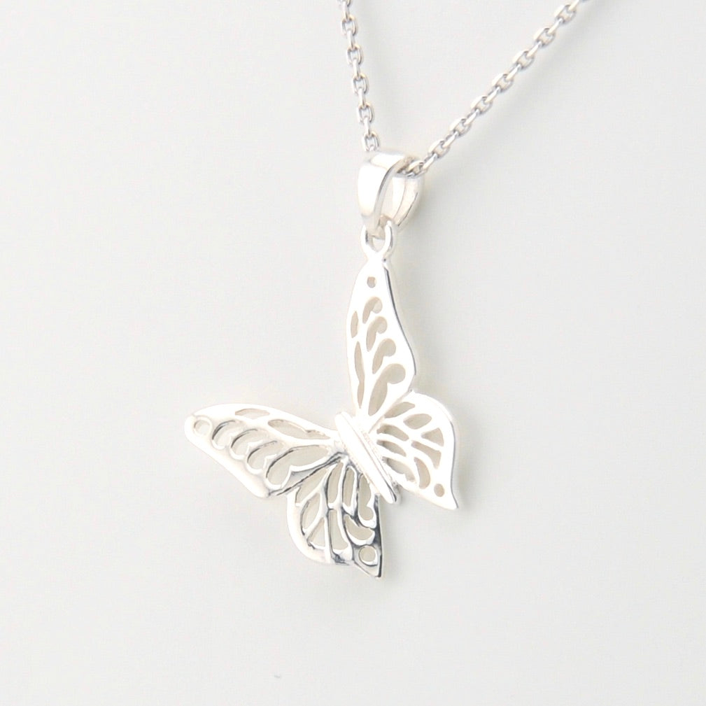 Silver butterfly pendant necklace on a light gray background