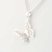 Silver butterfly pendant necklace on a light gray background