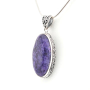 Purple pendant with silver frame on a white background