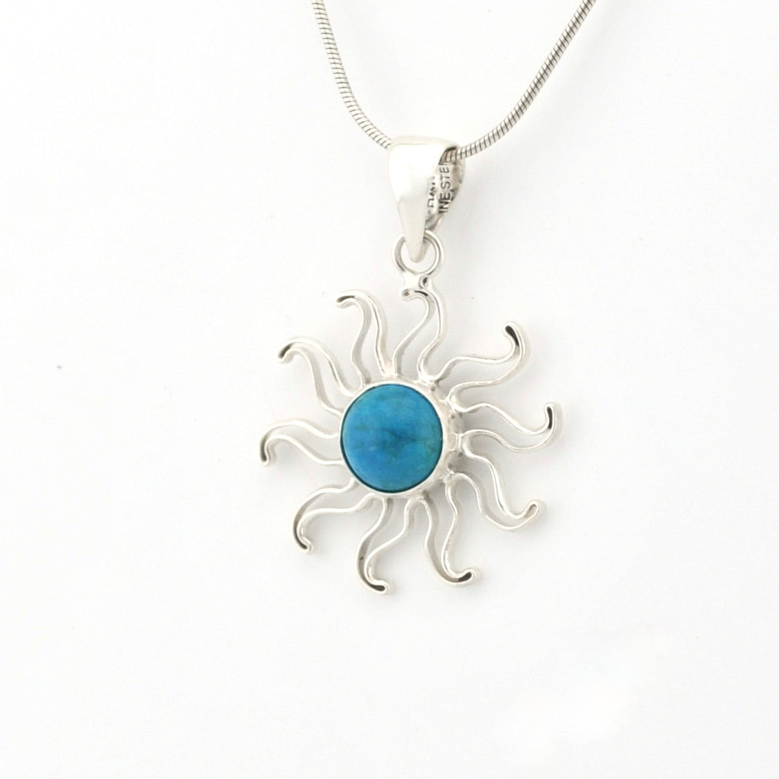 Silver sun-shaped pendant with a blue center on a white background