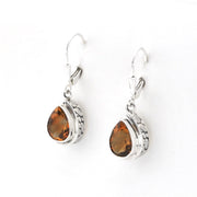 A pair of silver leverback drop earrings featuring teardrop-shaped cognac gemstones in a textured bezel setting, shown on a plain white background.