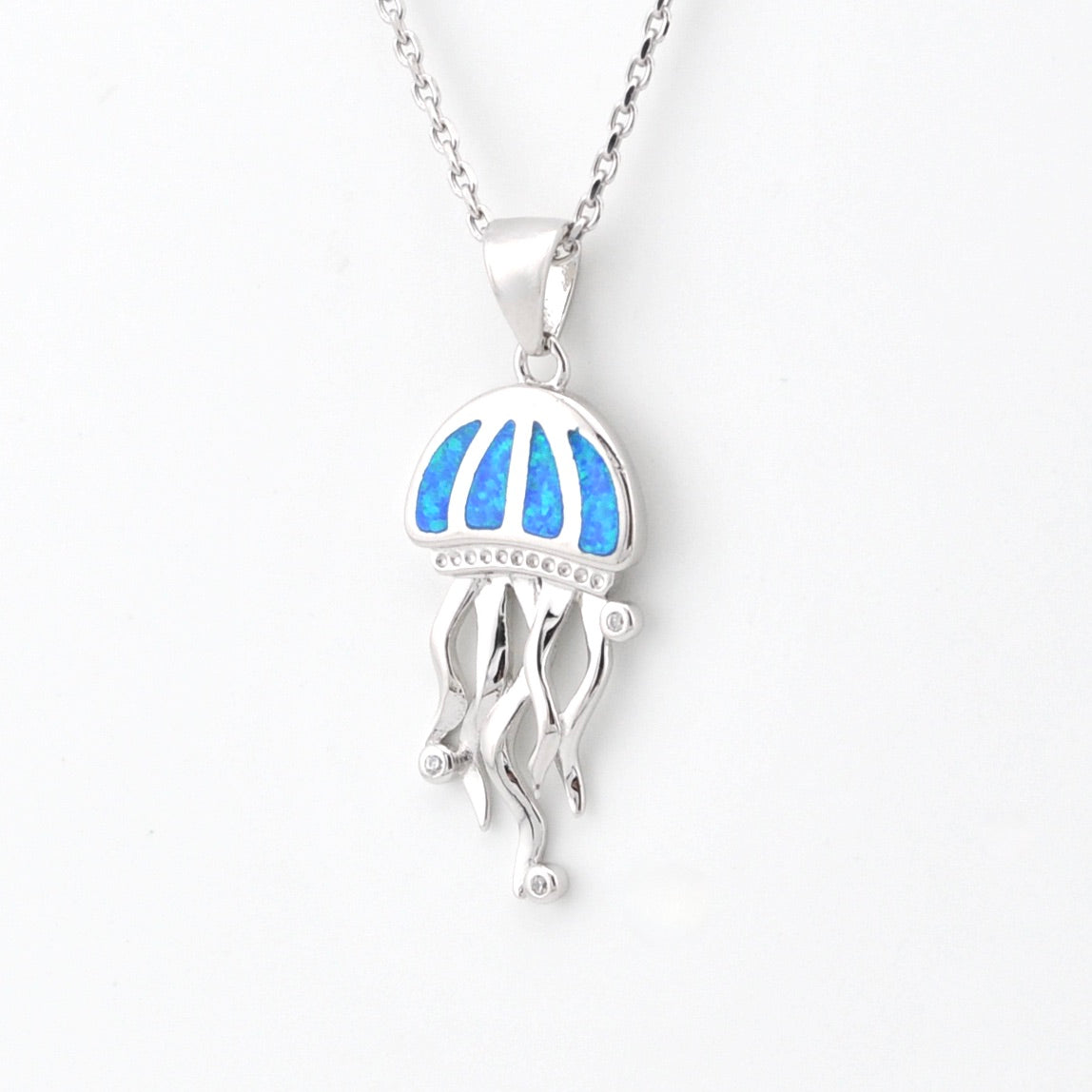 Silver jellyfish pendant with blue opal on a white background