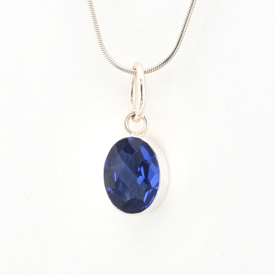 Blue gemstone pendant on a white background