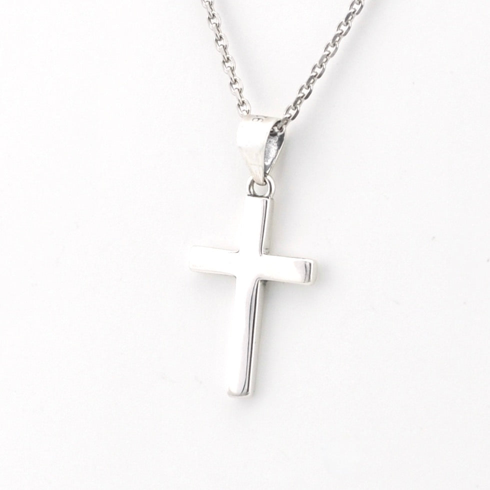 Silver cross pendant on a chain against a white background
