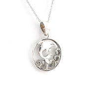 Silver pendant with a dolphin design on a white background
