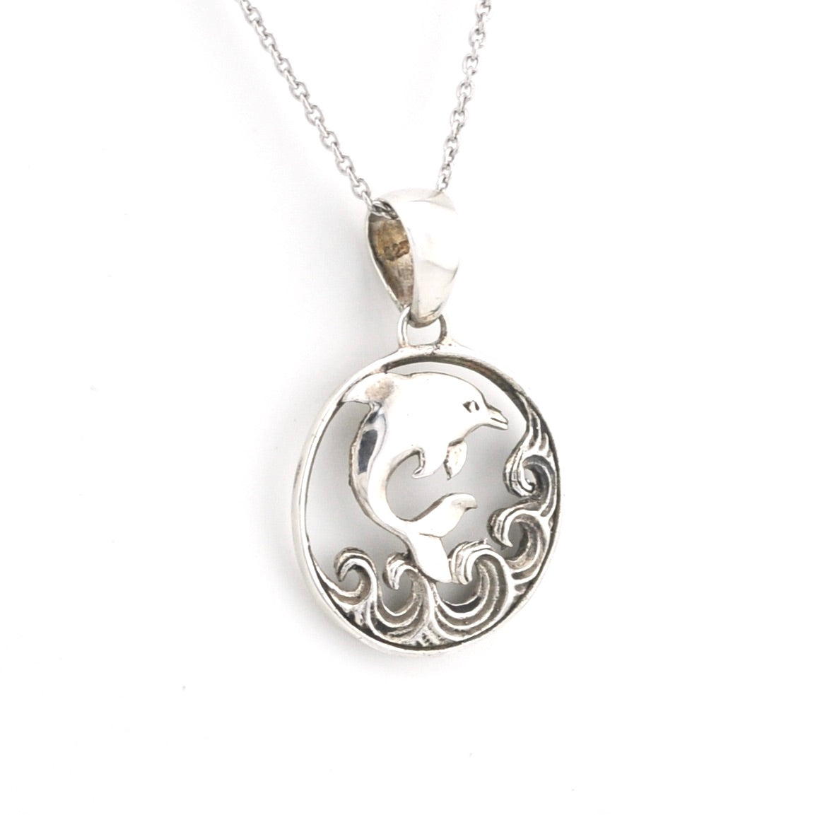 Silver pendant with a dolphin design on a white background