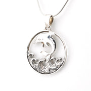 Silver pendant with dolphin design on a white background