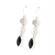 Pair of earrings with black, white, and gray stones on a white background
