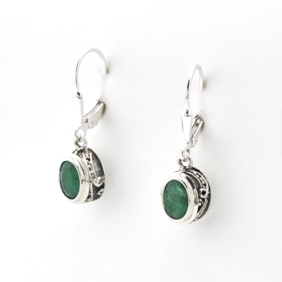 Silver earrings with green gemstones on a white background