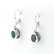 Silver earrings with green gemstones on a white background
