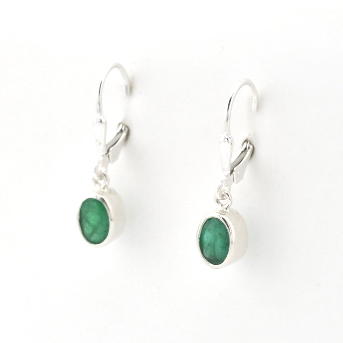 Silver earrings with green gemstones on a white background