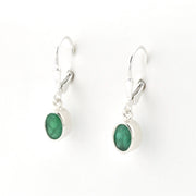 Silver earrings with green gemstones on a white background